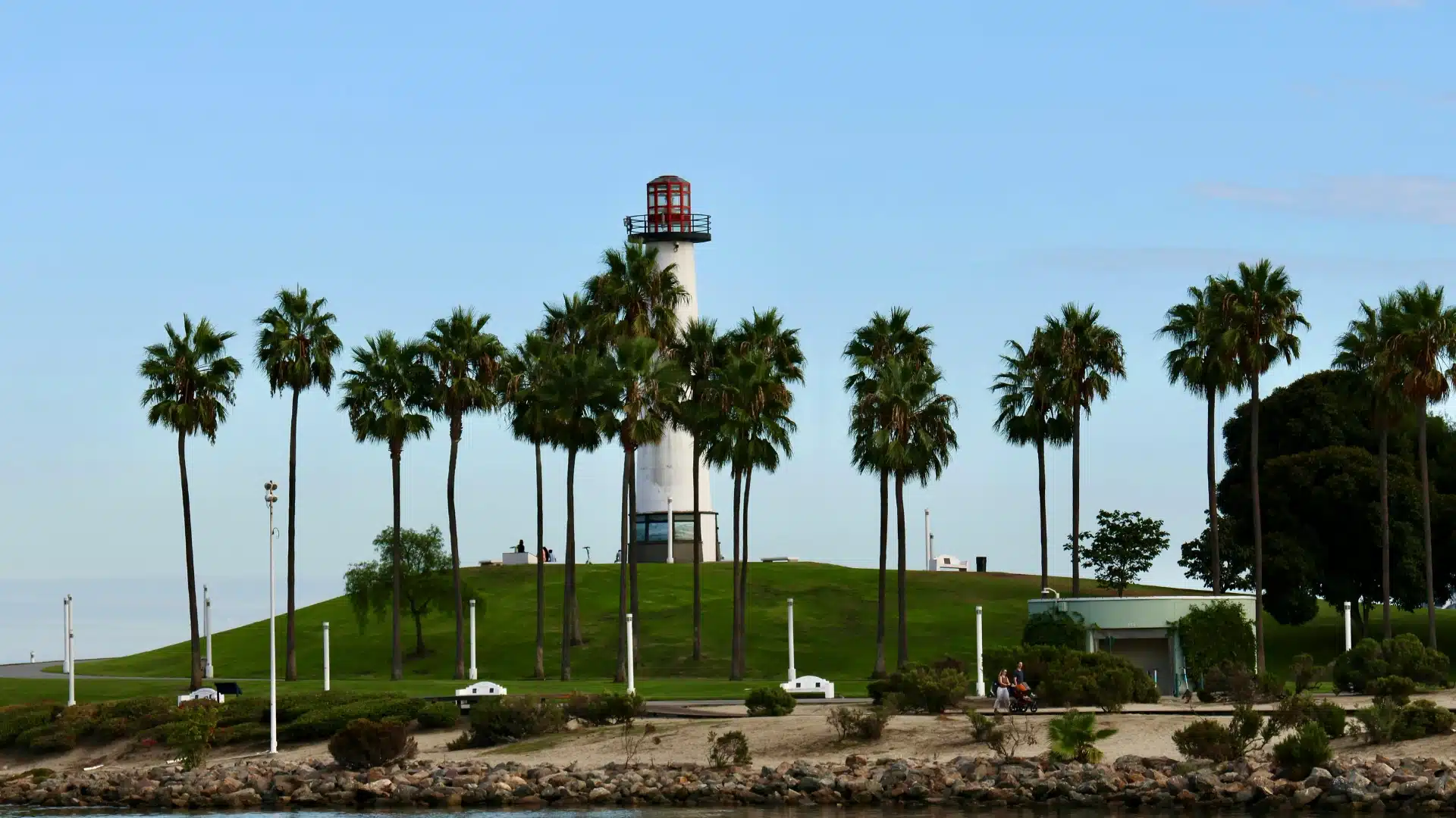 Long Beach area with palm trees, green landscaping, and a bright Southern California sky.